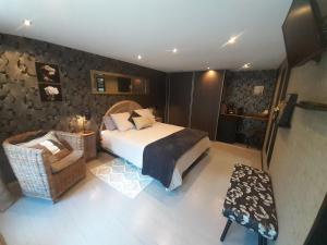 a bedroom with a bed and a chair at La chambre d'Hôt'ize in Bouillé-Courdault