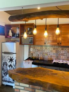 a kitchen with a counter top and a refrigerator at Chalé Lampião BG in Barra Grande
