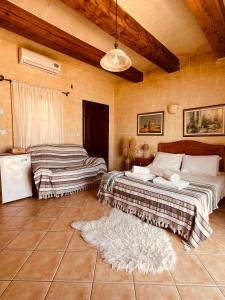 a bedroom with two beds and a rug at Narcisa Farmhouse B&B in Nadur +37 photos