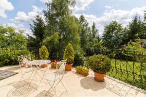 a patio with a table and chairs and potted plants at AMARI PARK Residence in Golyama Zhelyazna
