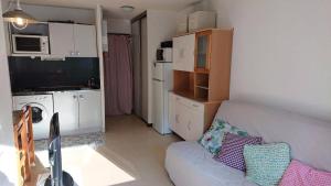 a living room with a couch and a kitchen at Résidence Relais - Charmant T2 pour 5 personnes au cœur de la station de Réallon 243R MAE-8941 in Réallon