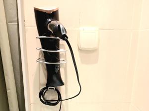 a black hair dryer hanging on a wall at Studio très haut standing avec vue dégagée in Tunis