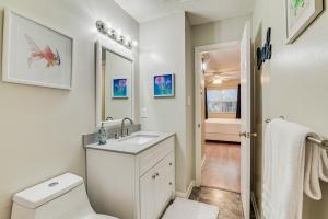 a white bathroom with a sink and a toilet at 1 Mi to Boardwalk and Dtwn Myrtle Beach Condo in Myrtle Beach +19 photos