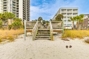 a pair of wooden stairs in the sand on the beach at 1 Mi to Boardwalk and Dtwn Myrtle Beach Condo in Myrtle Beach