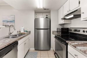 a kitchen with a stainless steel refrigerator and a sink at Shipwatch #114 in East End