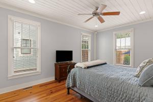 una camera da letto con un letto e un ventilatore a soffitto di Captain's Hangar a Wymberly-On-The-Marsh