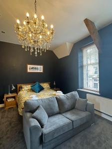 a bedroom with a couch and a bed with a chandelier at Cumberland House in Cockermouth