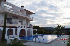 a hotel with a swimming pool in front of a building at Lofos Vourvourou in Vourvourou
