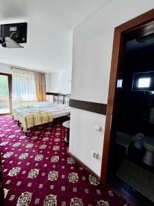 a bedroom with a bed and a red carpet at Crăiasa 2 in Moieciu de Sus +15 photos