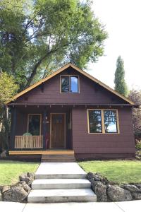 Una pequeña casa morada con un porche y escaleras en el frente. en Bluebird Day - Cinder Cone Bungalow, en Bend