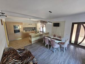 a kitchen and living room with a table and chairs at Vila Medana- Neamt in Humuleşti