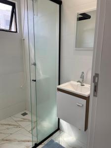 une salle de bain avec une douche en verre et un lavabo dans l'établissement S3 - Lindo Apartamento em região central, à Foz do Iguaçu 23 autres photos
