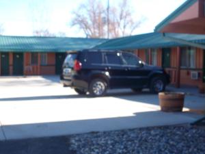 a black suv parked in front of a building at Western Motel Ranchester in Ranchester