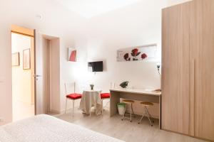 a bedroom with a bed and a desk and chairs at San Giovanni Rooms Roma in Rome