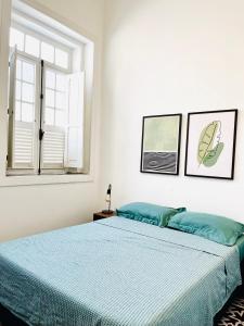 una camera da letto con un letto con lenzuola blu e una finestra di Draper Startup House - Rio de Janeiro a Rio de Janeiro