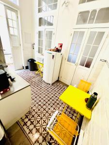 una cucina con tavolo giallo e frigorifero di Draper Startup House - Rio de Janeiro a Rio de Janeiro