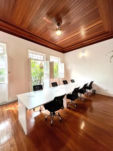un ufficio con un lungo tavolo e sedie bianchi di Draper Startup House - Rio de Janeiro a Rio de Janeiro Altre 17 foto