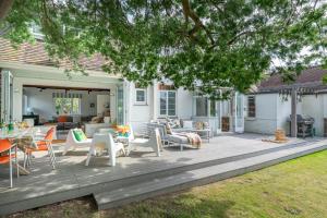 una terraza con sillas y mesas en una casa en Chantries, en Bembridge