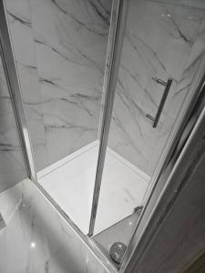 a shower with a glass door and a marble counter top at Tavellers Room in Delta DPF2 in Croydon