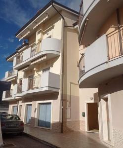 a building with balconies and a car parked next to it at Casa Porta Napoli in Castel di Sangro