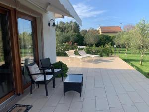 a patio with chairs and a bench and a table at La Casetta Holiday Home in Alghero