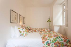 1 dormitorio con 2 camas y almohadas coloridas en Charming Apartment in Alfama, en Lisboa