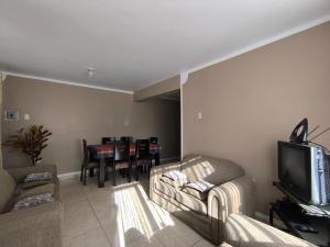 a living room with a couch and a tv and a table at Casa Waraq in Huaraz