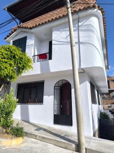 a white house with red chairs on the balcony at Casa Waraq in Huaraz