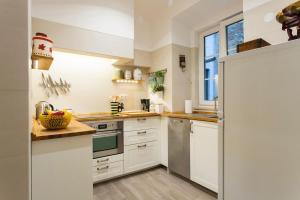 una cucina con armadietti bianchi e frigorifero di Charming Apartment in Alfama a Lisbona