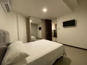 a bedroom with a large white bed and a mirror at Dpto 1 Dorm y balcon Baruc 3 Como en Casa - Scz in Santa Cruz de la Sierra