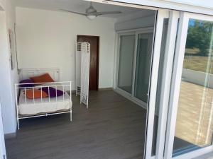 a room with a balcony with a bed and a window at Casa do Carpinteiro in Monte Claro