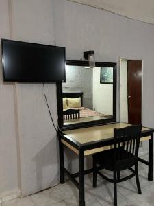 a mirror and a table with a chair in a room at Hotel Narváez Dorado Centro de Convenciones in Tuxtla Gutiérrez
