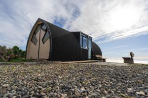 a black and white house on a rocky beach at Roca Cuadrada Lodge in Navidad