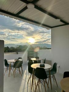 a room with tables and chairs on a balcony at Hotel Med Llanogrande in Rionegro