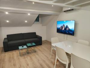 a living room with a black couch and a table at Blanche-Neige CLIM Ile Verte proche Hôpital in Grenoble