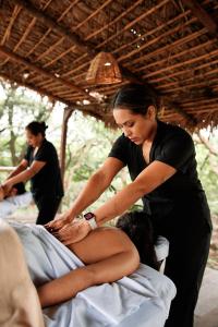 a woman sitting on a bed with a woman gettingthritisthritisthritisthritisthritisthritis at Escape Romántico en Tepoztlán, Habitación Privada y Céntrica in Tepoztlán