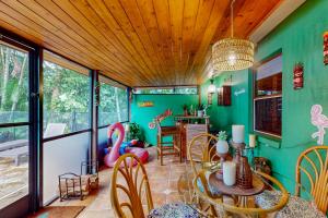 ein Esszimmer mit grünen Wänden und einem Tisch und Stühlen in der Unterkunft Coastal Paradise Getaway in Cape Coral