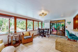 ein Wohnzimmer mit Tisch und Stühlen und Fenstern in der Unterkunft Coastal Paradise Getaway in Cape Coral