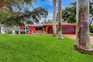 ein rotes Haus mit Palmen im Hof in der Unterkunft Coastal Paradise Getaway in Cape Coral