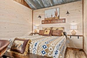 ein Schlafzimmer mit einem Bett in einem Zimmer mit Holzwänden in der Unterkunft Rockin' R - Shooting Star Cabin in Fredericksburg