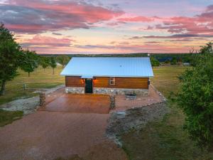 ein kleines Haus mit einem blauen Dach auf einem Feld in der Unterkunft Rockin' R - Shooting Star Cabin in Fredericksburg