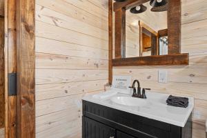 ein Badezimmer mit Waschbecken und Spiegel in der Unterkunft Rockin' R - Shooting Star Cabin in Fredericksburg + 34 Fotos