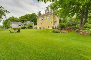 a large yellow house on a green lawn at The Watson House about 16 Mi to Sebago Lake! in Cornish