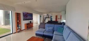 a living room with a blue couch and a tv at Exceptional villa in Vila Franca Do Campo with private pool in Vila Franca do Campo