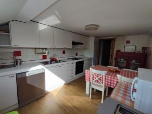 a kitchen with white cabinets and a table with a tablecloth at Piso céntrico cerca de la playa in Cedeira