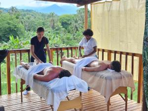 a group of men laying on beds on a deck at Natyva House in Guachaca