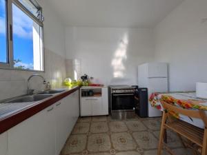 a kitchen with a sink and a stove at Maison F4 à Sainte - Anne, Guadeloupe in Sainte-Anne