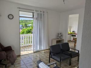 a living room with a chair and a window at Maison F4 à Sainte - Anne, Guadeloupe in Sainte-Anne