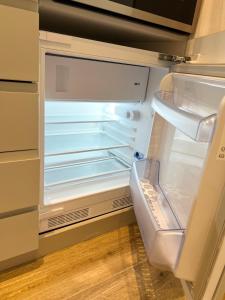 an empty refrigerator with its door open in a kitchen at Vienna Charm Apartments Meidling in Vienna
