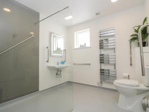 Un baño blanco con inodoro y lavabo. en Willow, en Truro 39 fotos más